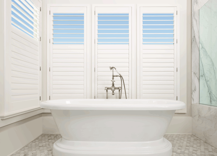 bathroom window treatments behind tub as plantation shutters with split tilt open top in Roseville CA