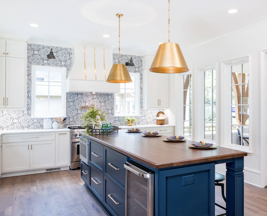 kitchen with wallpaper on walls and blue island with gold accents