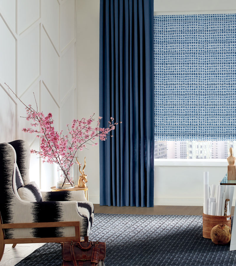 insulating window treatments with patterned blue roman shades and side draperies in Roseville, CA