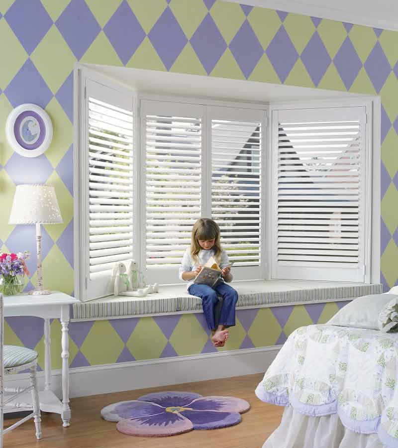 purple and green kids bedroom with white bay window shutters in Folsom, CA