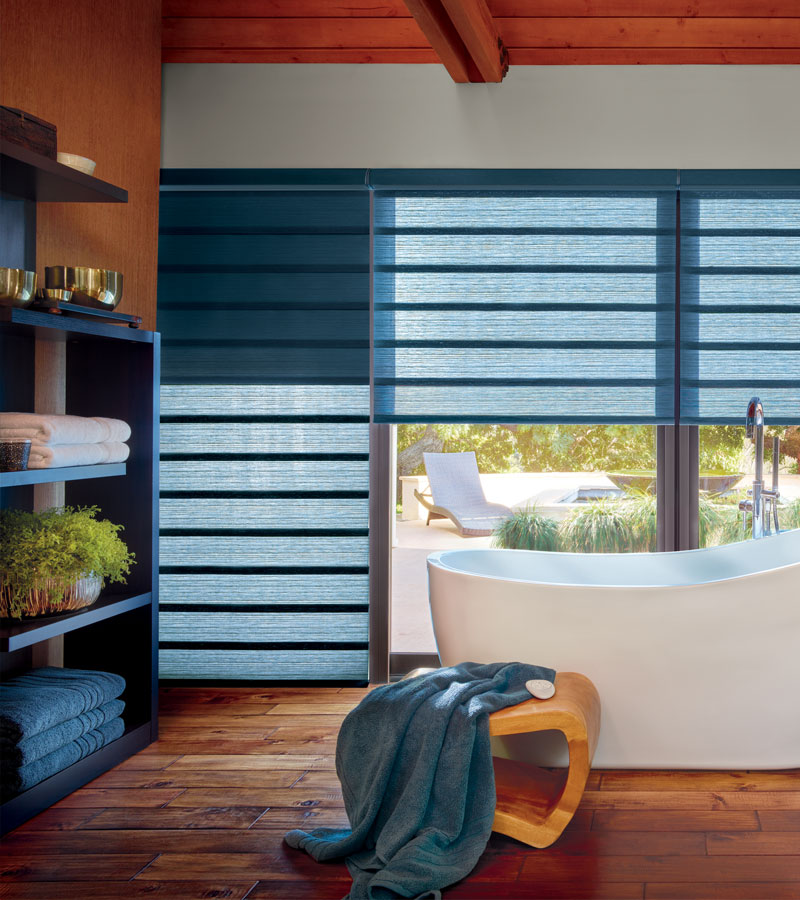 exterior wall of bathroom window with blue modern roman shades in Sacramento, CA