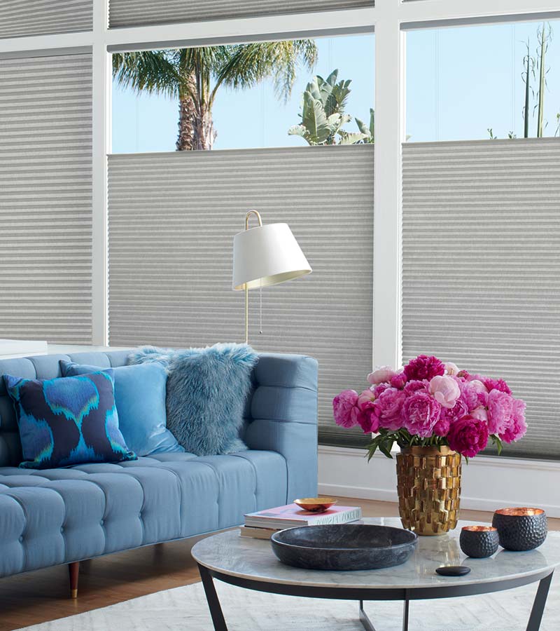 cellular blinds lowering from the top in living room with blue sofa in Rocklin, CA