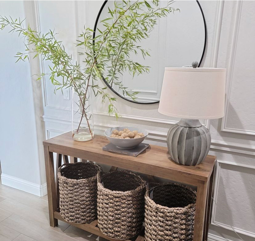 entryway table with baskets and greenery