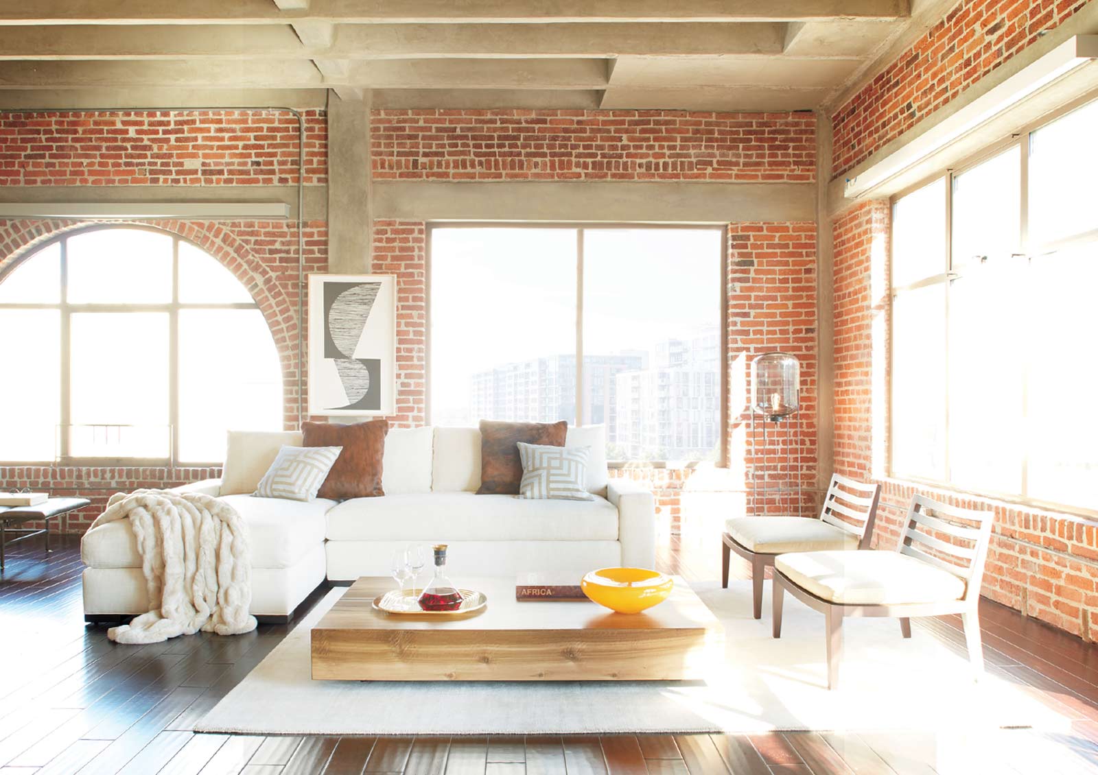 exposed brick living room without window treatments and light bleaching on furniture