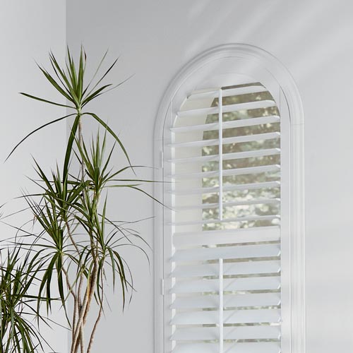 white hybrid shutters on arched window in Northern CA home