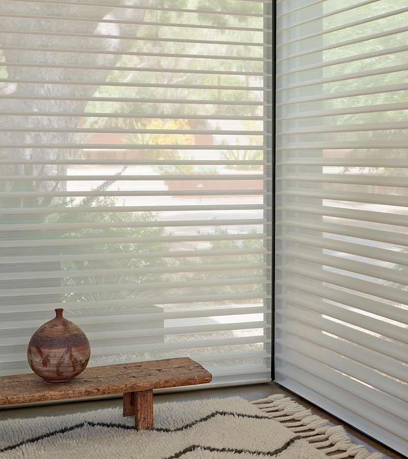 floor to ceiling light diffusing window shades with small bench and pottery