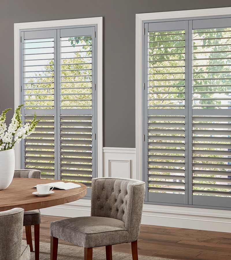 gray hardwood shutters letting light into dining room space