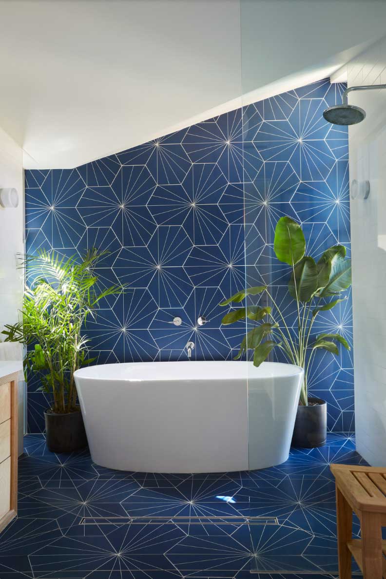blue tiled bathroom with white tub