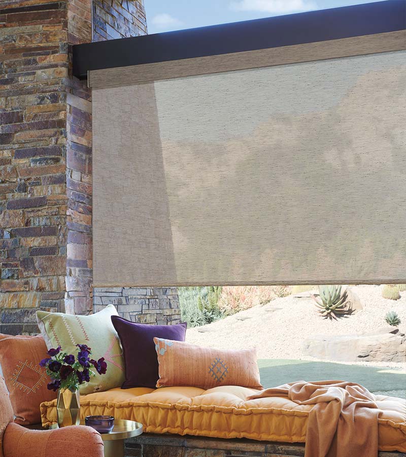 brown designer roller shades next to window seat