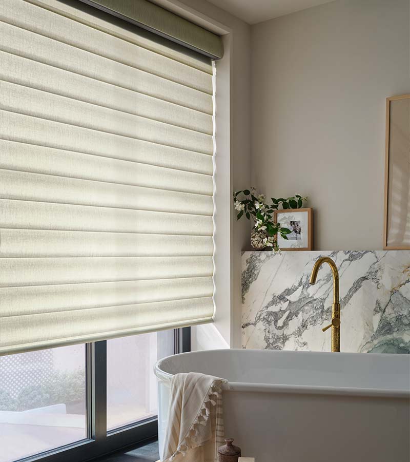 Pirouette shades diffusing sunlight with light-filtering fabrics on large bathroom windows