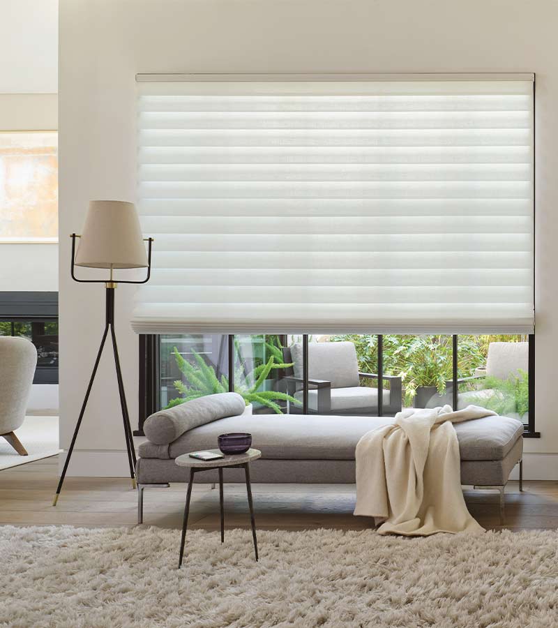 vignette-roman-shades-stacking-hunter-douglas-california-window-fashions Roman shades filtering natural light in a California living room