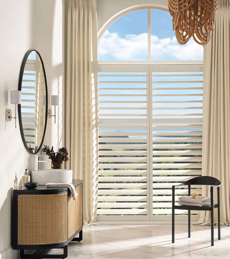 palm-beach-vinyl-shutters-primary-bathroom-california-window-fashions bathroom with palm beach vinyl shutters paired with custom drapery