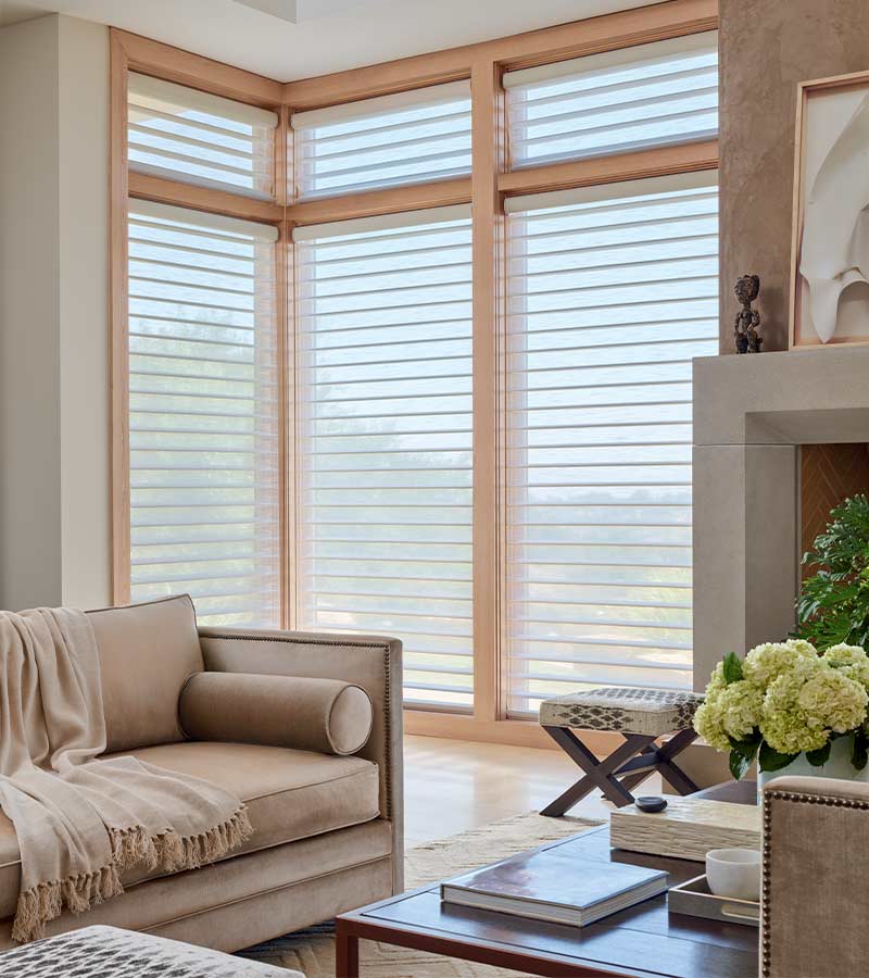 Silhouette® shades on tall corner windows creating soft light in a modern living room