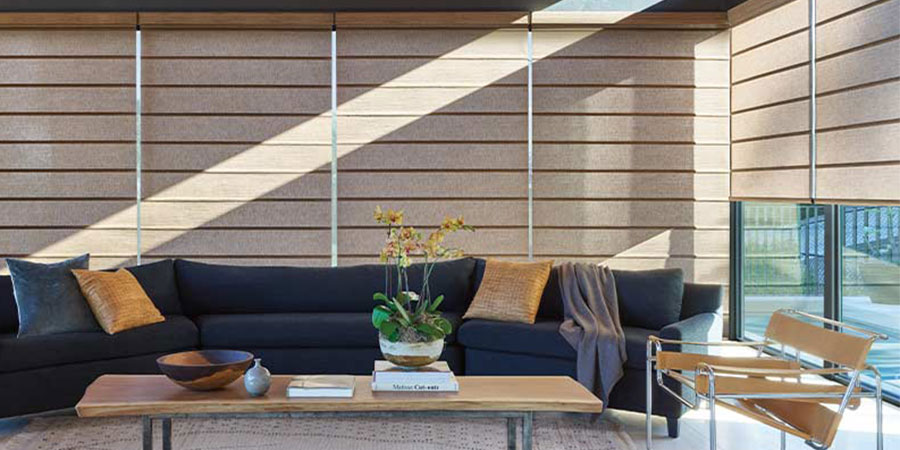 Alustra® Architectural Roller Shades protecting interiors from direct sunlight on multiple windows in living room